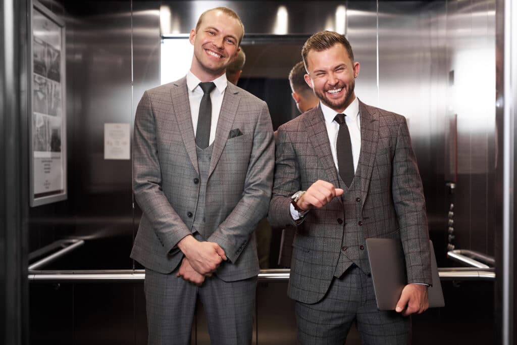 portrait of happy businessmen inside of elevator